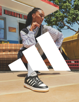 Model wearing cool black and white adidas sneaker in a retro look