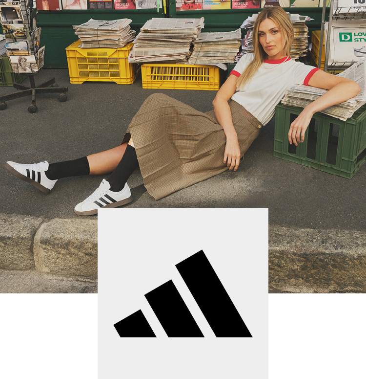Woman in front of a newspaper kiosk with adidas sneakers in retro look