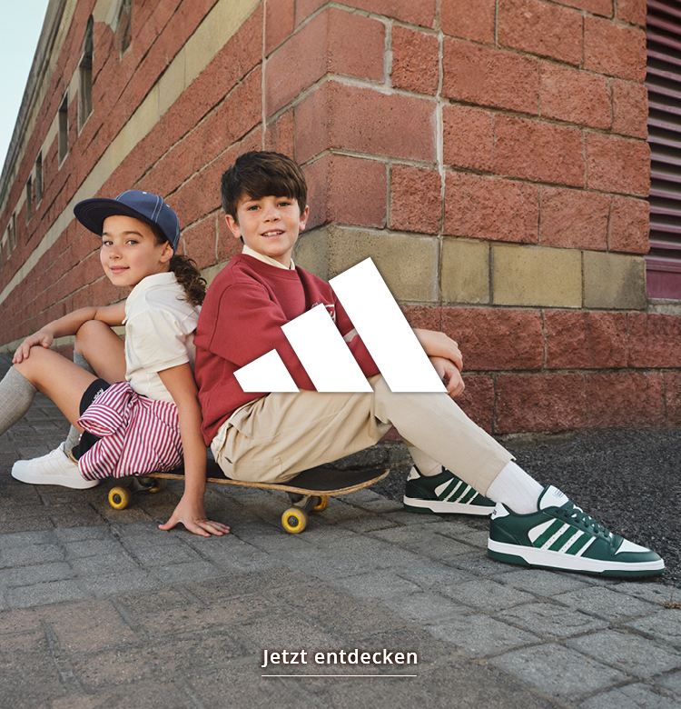 Kids mit adidas Sneaker Rücken an Rücken auf einem Skateboard