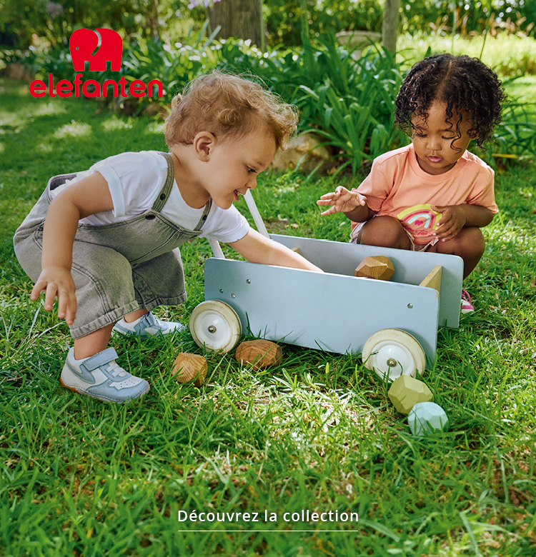 Enfants jouant dans le jardin avec des chaussures éléphantesques et des jouets en bois