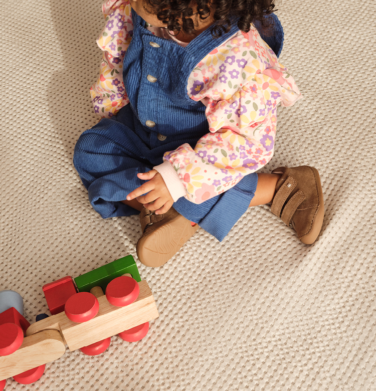 Child with wooden toys and elefanten shoes